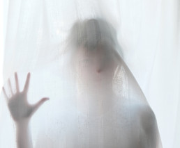 Woman behind curtains